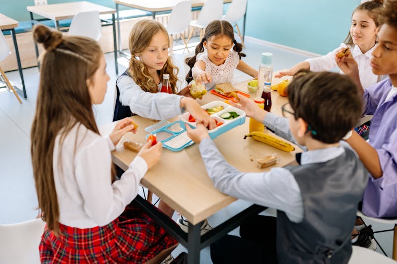 Siswa sekolah makan siang bersama di kantin